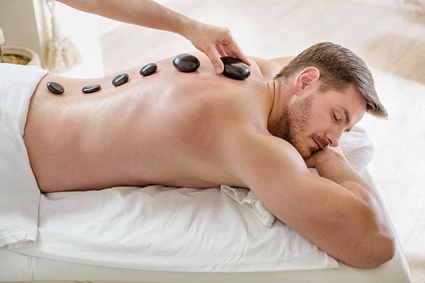 Hot stone massage with heated stones on the back.