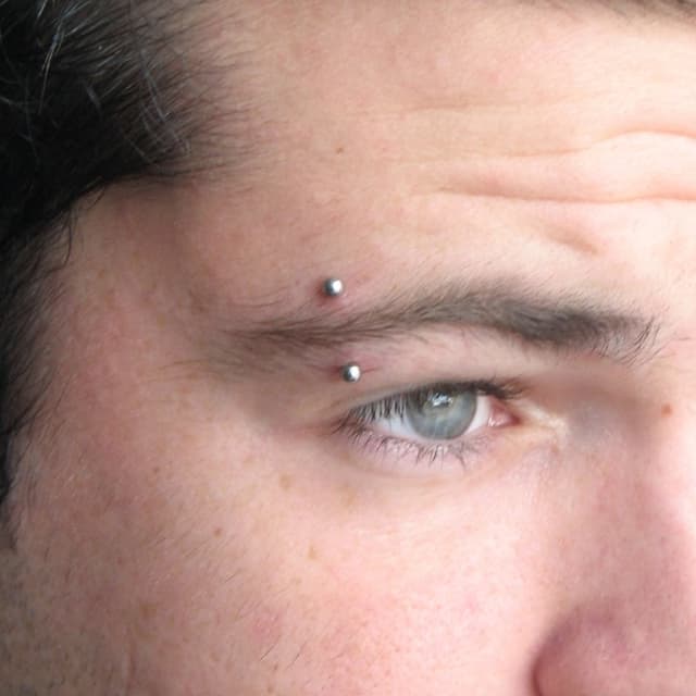 Eyebrow piercings with different placement options.