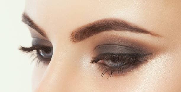 Smoky eye makeup with dark shadows.